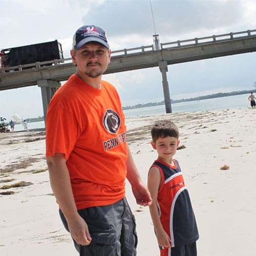 Tom and his kid at the beach