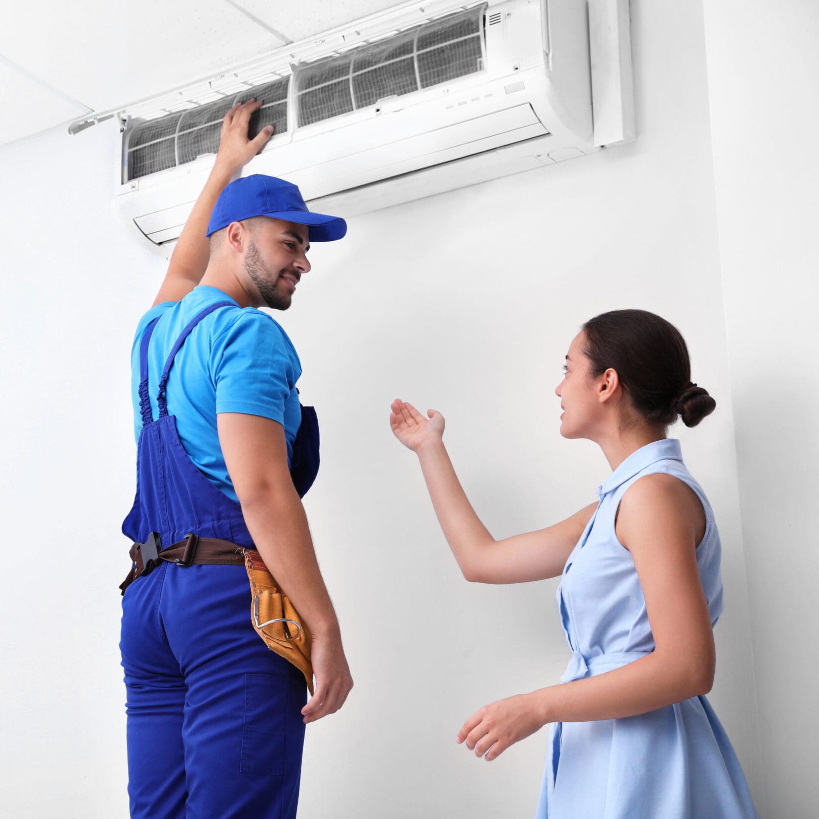 A woman speaking to an HVAC technician.